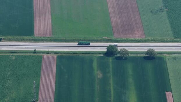 Aerial view of a truck driving on a highway through fields France.