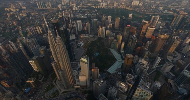 Aerial view of the iconic Petronas Twin Towers and the dense urban skyline with skyscrapers and green parks during twilight in Kuala Lumpur Federal Territory of Malaysia. Aerial view of the iconic Petronas Twin Towers and the dense urban skyline with skyscrapers and green parks during twilight in Kuala Lumpur Federal Territory of Malaysia.