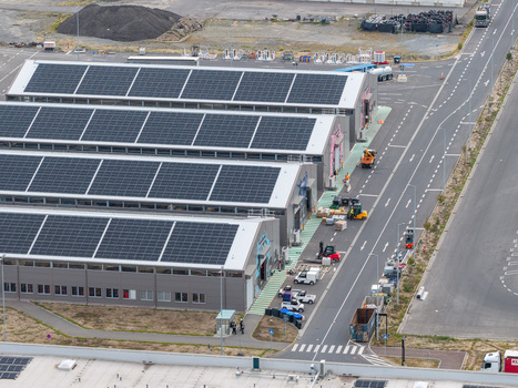 Aerial view of the Tesla Gigafactory Berlin Brandenburg featuring industrial buildings with solar panel arrays adjacent roads and logistics vehicles in Grunheide Mark Brandenburg Germany. Aerial view of the Tesla Gigafactory Berlin Brandenburg featuring industrial buildings with solar panel arrays adjacent roads and logistics vehicles in Grunheide Mark Brandenburg Germany.