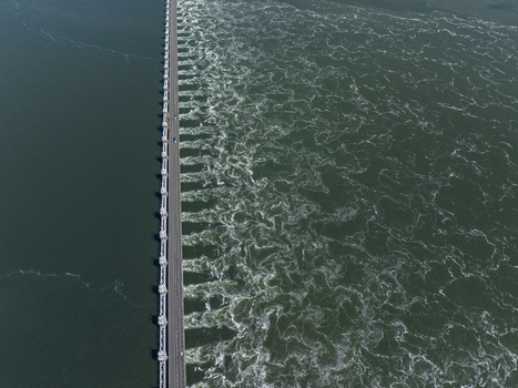 Aerial view of the Eastern Scheldt Storm Surge Barrier with water flowing through the sluice gates creating swirling patterns in Vrouwenpolder Zeeland Netherlands. Aerial view of the Eastern Scheldt Storm Surge Barrier with water flowing through the sluice gates creating swirling patterns in Vrouwenpolder Zeeland Netherlands.