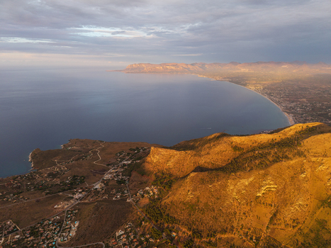 Aerial view of the rugged coastline and golden mountains of Sicily at sunset near Palermo Sicily Italy. Aerial view of the rugged coastline and golden mountains of Sicily at sunset near Palermo Sicily Italy.