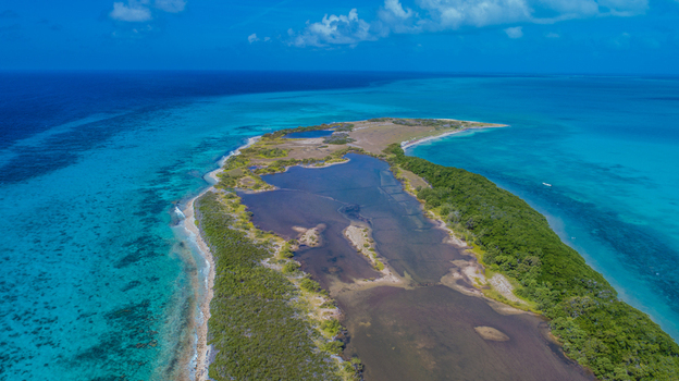 Aerial view of Los Roques archipelago featuring shallow lagoons lush vegetation and vibrant turquoise Caribbean waters in Los Roques Dependencias Federale Venezuela. Aerial view of Los Roques archipelago featuring shallow lagoons lush vegetation and vibrant turquoise Caribbean waters in Los Roques Dependencias Federale Venezuela.