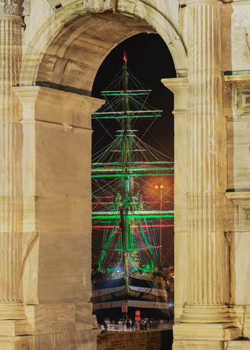 Ancona Italy 12 October 2022 View of the historic Amerigo Vespucci sailing ship illuminated at night framed by the ancient stone columns of the Arch of Trajan in Ancona Italy.