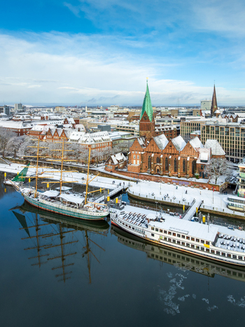 Aerial view of St. Martin s Church along the Weser river with snow covered rooftops and docked ships in Bremen Germany. Aerial view of St. Martin s Church along the Weser river with snow covered rooftops and docked ships in Bremen Germany.