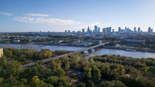 Aerial view of bridges spanning a wide river contrasting with the lush greenery of Park Praski and the towering skyline Warsaw Poland. Aerial view of bridges spanning a wide river contrasting with the lush greenery of Park Praski and the towering skyline Warsaw Poland.