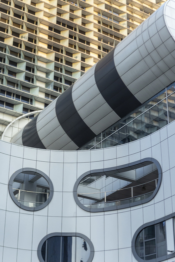 View of modern architectural details featuring a striped cylindrical structure and oval windows on a contemporary building facade in Taipei City Taiwan. View of modern architectural details featuring a striped cylindrical structure and oval windows on a contemporary building facade in Taipei City Taiwan.