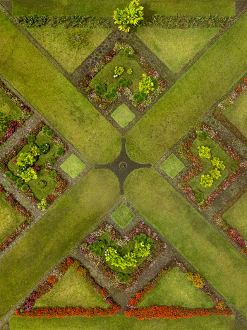 Aerial view of the symmetrical geometric patterns of a formal garden with colorful flower beds and manicured green lawns in Cinchona Alajuela Province Costa Rica. Aerial view of the symmetrical geometric patterns of a formal garden with colorful flower beds and manicured green lawns in Cinchona Alajuela Province Costa Rica.