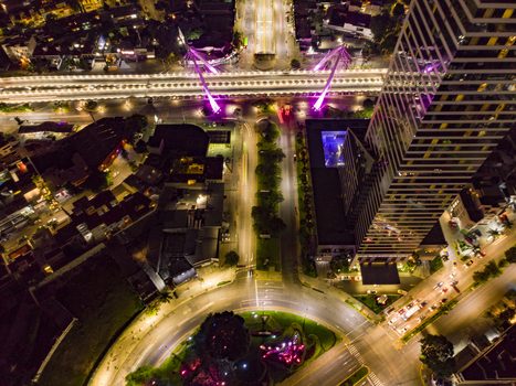 Aerial view of the illuminated Glorieta Stampede roundabout at night featuring the modern skyscraper vibrant pink bridge lighting and traffic light trails in Guadalajara Jalisco Mexico. Aerial view of the illuminated Glorieta Stampede roundabout at night featuring the modern skyscraper vibrant pink bridge lighting and traffic light trails in Guadalajara Jalisco Mexico.