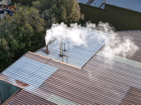 Aerial view of industrial factory rooftops with steam rising from metal vents in Kilsyth South Melbourne VIC Australia. Aerial view of industrial factory rooftops with steam rising from metal vents in Kilsyth South Melbourne VIC Australia.