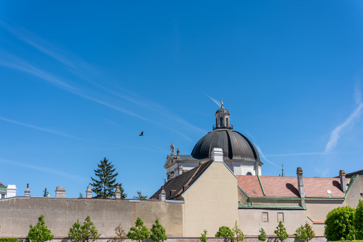 View of the Belvedere Palace featuring its prominent dark dome and historic rooftops under a clear blue sky in Vienna Austria. View of the Belvedere Palace featuring its prominent dark dome and historic rooftops under a clear blue sky in Vienna Austria.