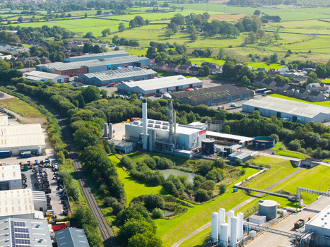 Aerial view of an industrial facility with warehouses storage tanks and railway tracks surrounded by green fields and trees in Lisburn Northern Ireland United Kingdom. Aerial view of an industrial facility with warehouses storage tanks and railway tracks surrounded by green fields and trees in Lisburn Northern Ireland United Kingdom.