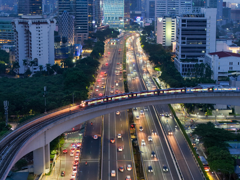 Aerial view of Jalan Gatot Subroto highway with an elevated light rail train heavy traffic flow and surrounding skyscrapers in Kecamatan Mampang Prapatan Daerah Khusus Ibukota Indonesia. Aerial view of Jalan Gatot Subroto highway with an elevated light rail train heavy traffic flow and surrounding skyscrapers in Kecamatan Mampang Prapatan Daerah Khusus Ibukota Indonesia.