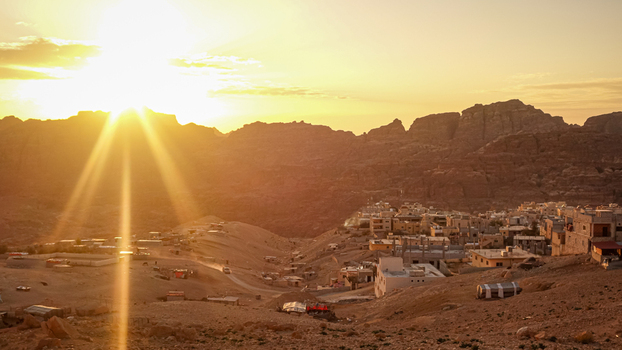 View of Wadi Rum Desert landscape with the village of Wadi Rum at sunset featuring golden light rocky mountains and desert terrain in Wadi Rum Village Aqaba Governorate Jordan. View of Wadi Rum Desert landscape with the village of Wadi Rum at sunset featuring golden light rocky mountains and desert terrain in Wadi Rum Village Aqaba Governorate Jordan.