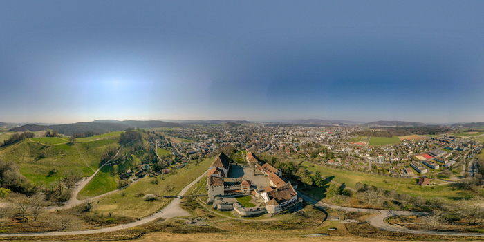 Aerial view of Lenzburg Castle on a hilltop overlooking the town and surrounding green landscape under a clear blue sky Lenzburg Aargau Switzerland. Aerial view of Lenzburg Castle on a hilltop overlooking the town and surrounding green landscape under a clear blue sky Lenzburg Aargau Switzerland.