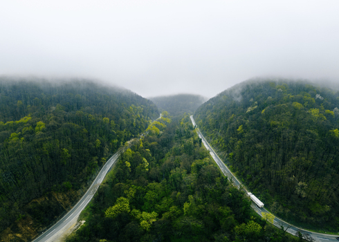 Aerial view of winding roads slicing through verdant hills with a touch of ethereal mist clinging to the mountaintops Novi Sad Vojvodina Serbia. Aerial view of winding roads slicing through verdant hills with a touch of ethereal mist clinging to the mountaintops Novi Sad Vojvodina Serbia.