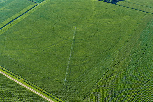 Aerial view of a center pivot irrigation system in a lush green corn field with circular patterns and a straight irrigation arm in Hombourg Grand Est France. Aerial view of a center pivot irrigation system in a lush green corn field with circular patterns and a straight irrigation arm in Hombourg Grand Est France.
