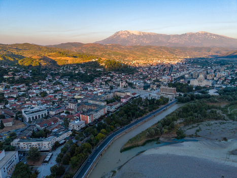 Aerial view of the historic city of Berat with its traditional rooftops the Osum River and surrounding mountains under golden hour light in Berat Berat County Albania.