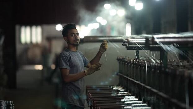 View of a worker operating a textile machine in Bogura Bangladesh.