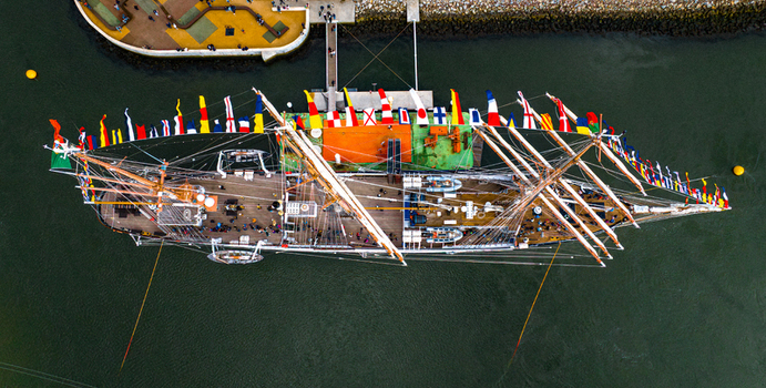 Aerial view of the tall ship NRP Sagres decorated with signal flags navigating the Canal de Aveiro near the salt pans Aveiro Aveiro Portugal. Aerial view of the tall ship NRP Sagres decorated with signal flags navigating the Canal de Aveiro near the salt pans Aveiro Aveiro Portugal.