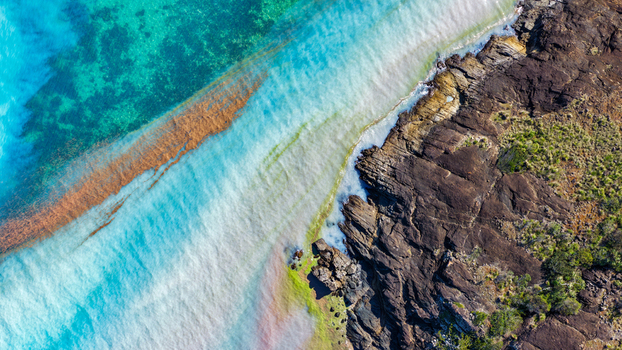 Aerial view of Chance Bay featuring turquoise waters rocky coastline and vibrant coral reefs in Whitsundays Queensland Australia. Aerial view of Chance Bay featuring turquoise waters rocky coastline and vibrant coral reefs in Whitsundays Queensland Australia.