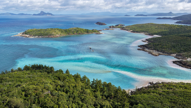 Aerial view of Chance Bay with turquoise waters lush green vegetation and rocky coastline in Whitsundays Queensland Australia. Aerial view of Chance Bay with turquoise waters lush green vegetation and rocky coastline in Whitsundays Queensland Australia.