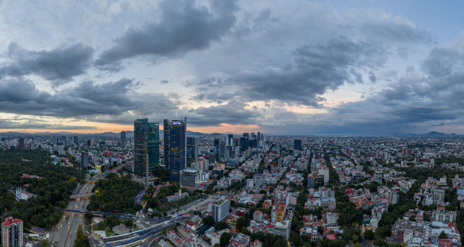 Mexico City Mexico 25 September 2026 Aerial view of the Mexico City skyline featuring modern skyscrapers dense urban development and lush green spaces under cloudy skies. Mexico City Mexico 25 September 2026 Aerial view of the Mexico City skyline featuring modern skyscrapers dense urban development and lush green spaces under cloudy skies.