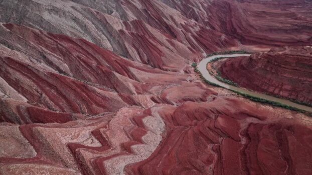 Aerial view of red rock formations and a winding river in Moab United States.
