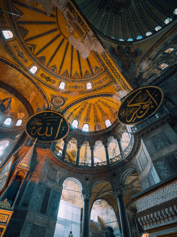 Istanbul Turkiye 07 October 2019 View of the Hagia Sophia s grand dome a symphony of golden hues soars above adorned with intricate calligraphy against a backdrop of aged stone.