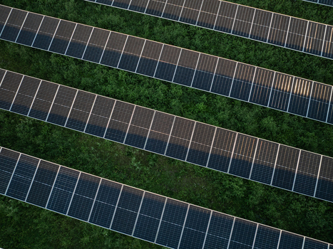 Aerial view of rows of photovoltaic solar panels installed over lush green vegetation in a solar farm in Augusta Sicily Italy. Aerial view of rows of photovoltaic solar panels installed over lush green vegetation in a solar farm in Augusta Sicily Italy.