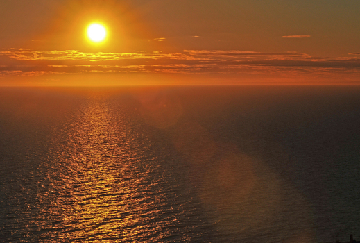 View of the golden sunset over the calm Atlantic Ocean with sun rays reflecting on the water surface at Puerto Piramides Puerto Madryn Chubut Argentina. View of the golden sunset over the calm Atlantic Ocean with sun rays reflecting on the water surface at Puerto Piramides Puerto Madryn Chubut Argentina.