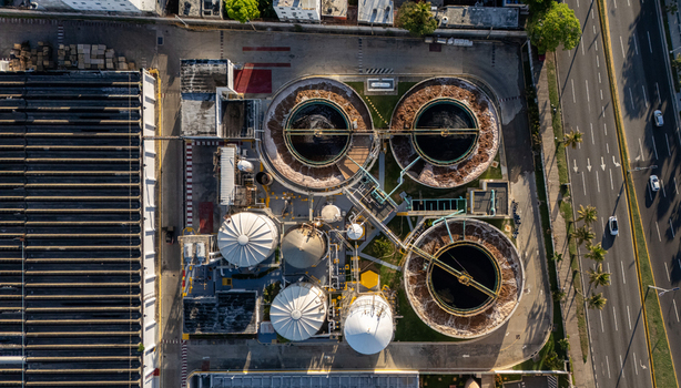 Aerial view of a beer industrial complex featuring large circular fermentation tanks storage silos and industrial infrastructure next to a highway in Santo Domingo Dominican Republic. Aerial view of a beer industrial complex featuring large circular fermentation tanks storage silos and industrial infrastructure next to a highway in Santo Domingo Dominican Republic.