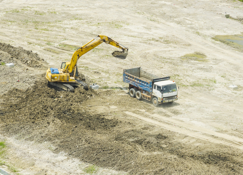 Aerial view of a yellow excavator loading soil into a blue dump truck at a construction site in Taiwan. Aerial view of a yellow excavator loading soil into a blue dump truck at a construction site in Taiwan.
