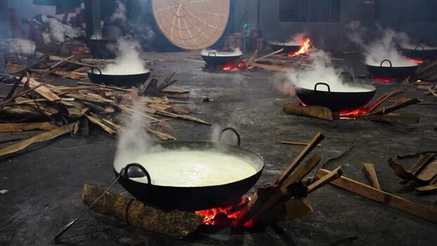 View of boiling milk in large pots over wood fires Bangladesh. View of boiling milk in large pots over wood fires Bangladesh.