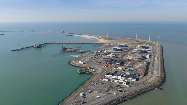 Aerial view of the Fluxys LNG Terminal Zeebrugge featuring storage tanks industrial infrastructure and wind turbines along the coastline in Brugge Vlaanderen Belgium. Aerial view of the Fluxys LNG Terminal Zeebrugge featuring storage tanks industrial infrastructure and wind turbines along the coastline in Brugge Vlaanderen Belgium.
