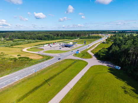 Saulgozi Latvia 05 July 2026 Aerial view of Virsi gas station located along the Via Baltica road surrounded by green fields forests and highway infrastructure under a blue sky.