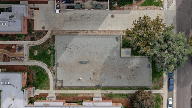 Aerial view of a fenced dog park in the Cherry Creek area with sandy ground agility equipment surrounding walkways and mature trees in Denver Colorado United States. Aerial view of a fenced dog park in the Cherry Creek area with sandy ground agility equipment surrounding walkways and mature trees in Denver Colorado United States.