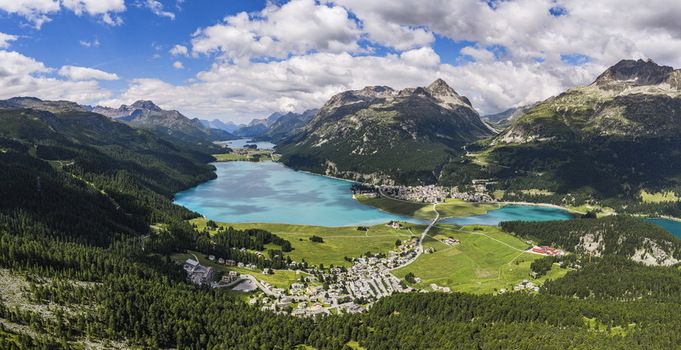Aerial view of the village of Surlej and Silvaplana situated between the turquoise waters of Lake Silvaplana and the lush green slopes of the Swiss Alps in Silvaplana Grisons Switzerland.