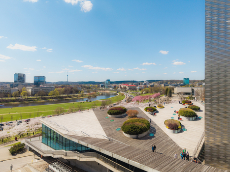 Aerial view of Chiune Sugihara Sakura Park with its modern building wooden deck circular planters and people walking along the river in Vilnius Vilniaus apskritis Lithuania. Aerial view of Chiune Sugihara Sakura Park with its modern building wooden deck circular planters and people walking along the river in Vilnius Vilniaus apskritis Lithuania.