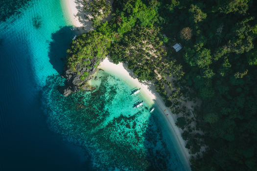 Aerial view of Papaya Beach featuring turquoise waters coral reefs white sand and lush tropical forest in El Nido Mimaropa Philippines. Aerial view of Papaya Beach featuring turquoise waters coral reefs white sand and lush tropical forest in El Nido Mimaropa Philippines.