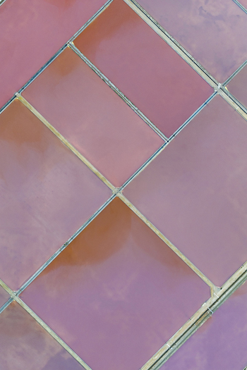 Aerial view of the vibrant hues of pink and orange salt ponds create a geometric mosaic under the clear sky San Pedro del Pinatar Region of Murcia Spain. Aerial view of the vibrant hues of pink and orange salt ponds create a geometric mosaic under the clear sky San Pedro del Pinatar Region of Murcia Spain.