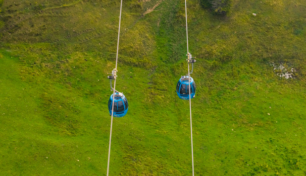 Compatsch Italy 18 September 2026 Aerial view of Seiser Alm cable car gondolas gliding over vibrant green alpine meadows in the Dolomites. Compatsch Italy 18 September 2026 Aerial view of Seiser Alm cable car gondolas gliding over vibrant green alpine meadows in the Dolomites.