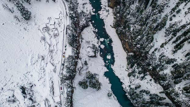 Aerial view of the turquoise river cutting through the snow laden landscape framed by dense dark coniferous trees Sharda Azad Kashmir Pakistan. Aerial view of the turquoise river cutting through the snow laden landscape framed by dense dark coniferous trees Sharda Azad Kashmir Pakistan.
