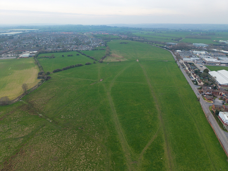 Aerial view of expansive green fields meeting the edge of a built up area under a muted sky Southampton United Kingdom. Aerial view of expansive green fields meeting the edge of a built up area under a muted sky Southampton United Kingdom.
