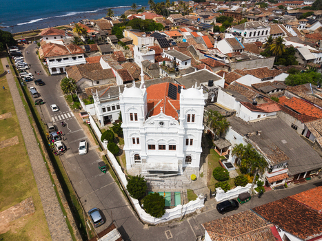 Aerial view of the historic Meeran Jumma Mosque with its white facade and red tiled roofs surrounded by the old town streets and coastal scenery in Galle Southern Province Sri Lanka. Aerial view of the historic Meeran Jumma Mosque with its white facade and red tiled roofs surrounded by the old town streets and coastal scenery in Galle Southern Province Sri Lanka.