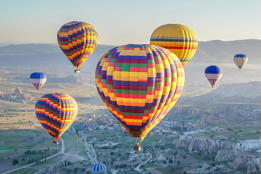 Aerial view of colorful hot air balloons floating over the unique rock formations and valleys of Cappadocia in Kayseri Kayseri Turkiye. Aerial view of colorful hot air balloons floating over the unique rock formations and valleys of Cappadocia in Kayseri Kayseri Turkiye.