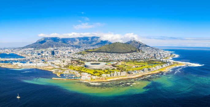 Aerial view of Table Mountain under clouds Lion s Head and the Cape Town Stadium along the coastline in Cape Town Western Cape South Africa.
