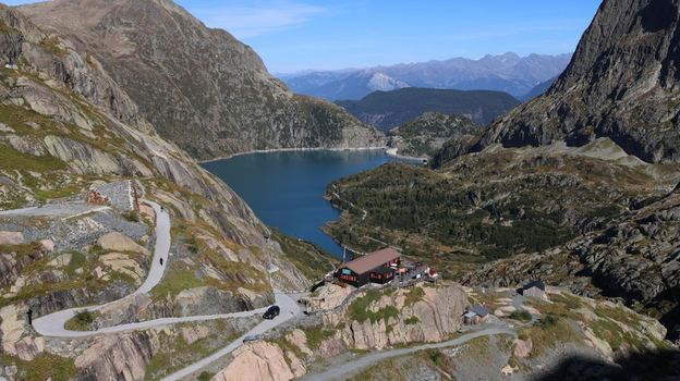View of Lac du Vieux Emosson surrounded by rugged mountain peaks a winding road and a mountain hut in Finhaut Valais Switzerland. View of Lac du Vieux Emosson surrounded by rugged mountain peaks a winding road and a mountain hut in Finhaut Valais Switzerland.
