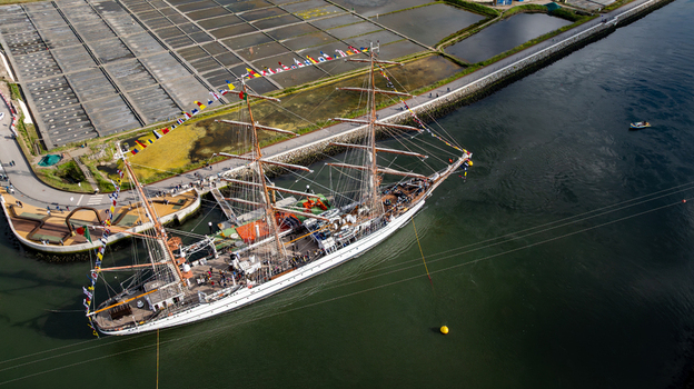 Aerial view of the tall ship NRP Sagres decorated with signal flags navigating the Canal de Aveiro near the salt pans Aveiro Aveiro Portugal. Aerial view of the tall ship NRP Sagres decorated with signal flags navigating the Canal de Aveiro near the salt pans Aveiro Aveiro Portugal.
