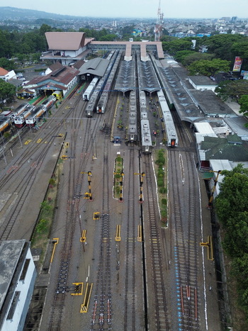 Aerial view of Stasiun Malang Kota Baru with multiple train tracks platforms and surrounding urban landscape in Kecamatan Klojen Jawa Timur Indonesia.
