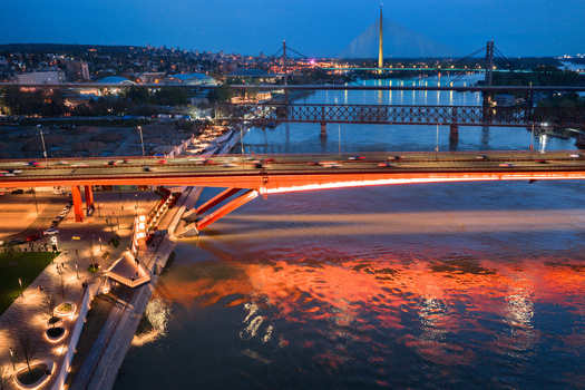 Aerial view of the illuminated Gazela Bridge and Ada Bridge spanning the Sava River with city lights reflecting on the water in Belgrade City of Belgrade Serbia. Aerial view of the illuminated Gazela Bridge and Ada Bridge spanning the Sava River with city lights reflecting on the water in Belgrade City of Belgrade Serbia.